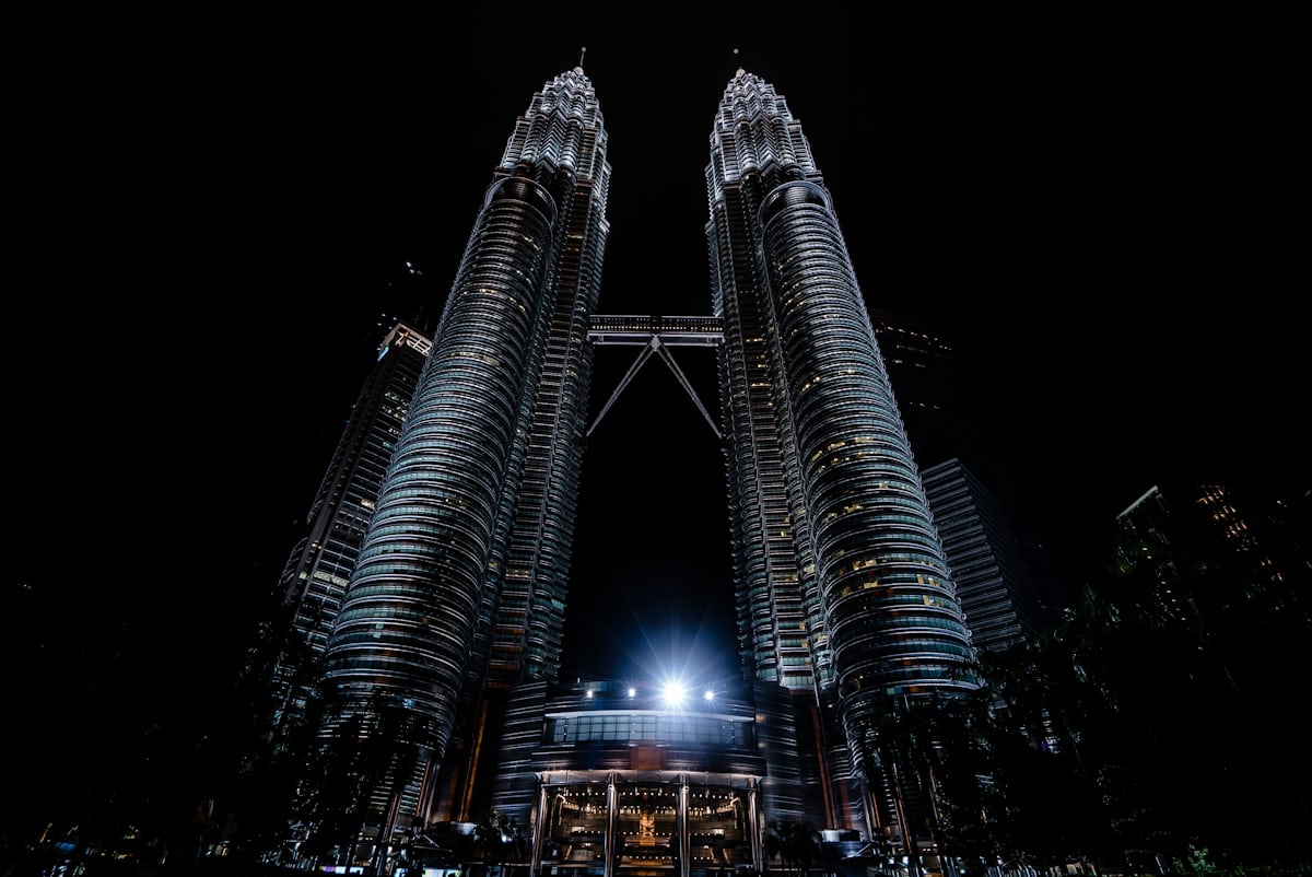 The towers illuminated at night against the Kuala Lumpur skyline